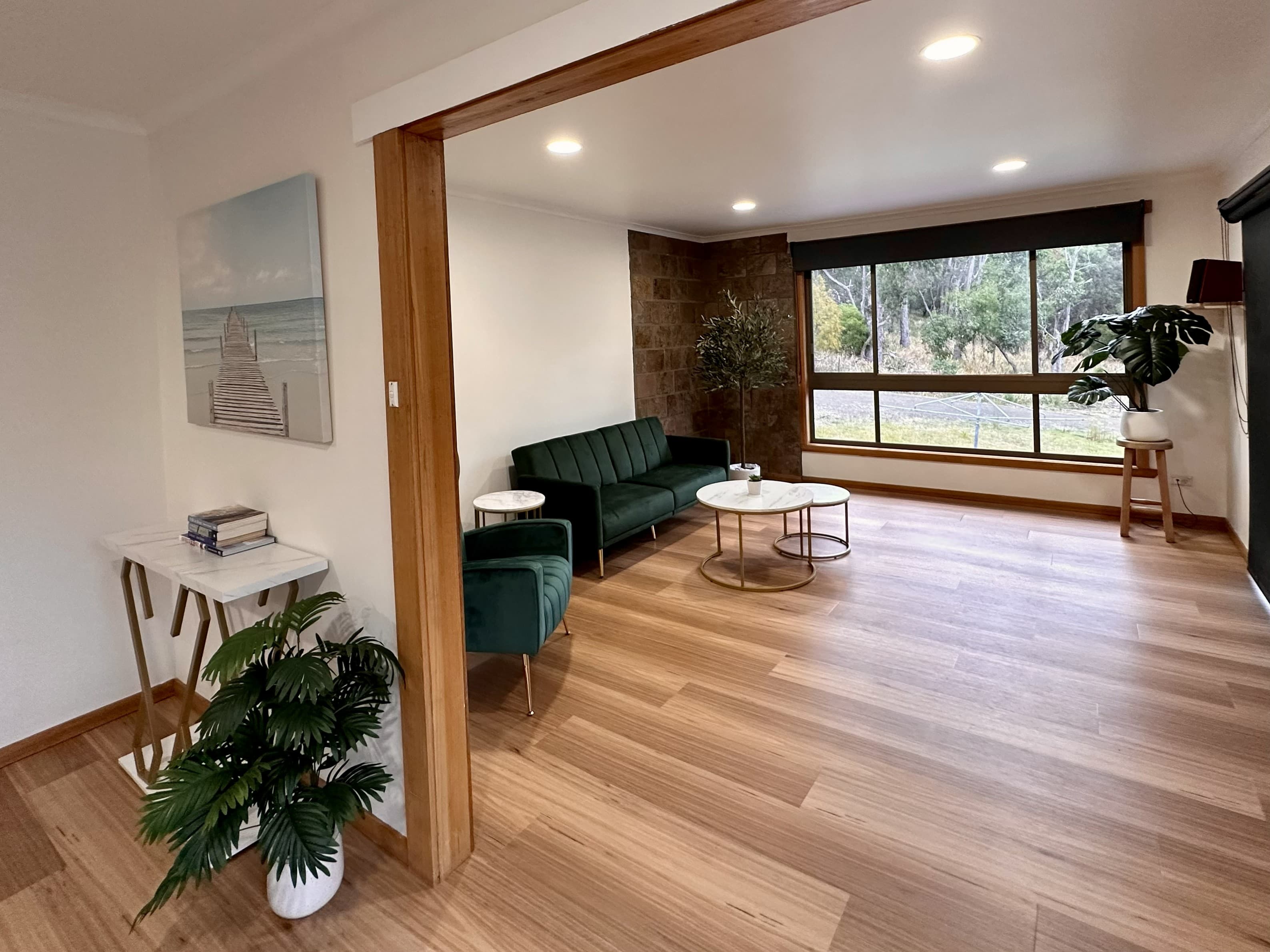 LunaStay — open plan living with timber floors and stone feature wall