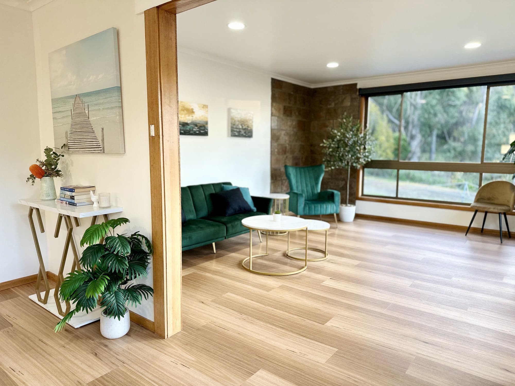 LunaStay — open plan living with timber floors, stone feature wall and velvet furnishings