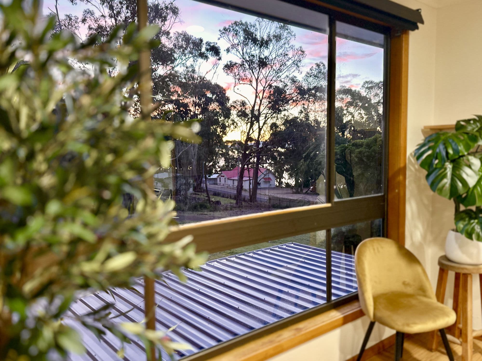 LunaStay — sunset over the water glimpsed through the sunroom window